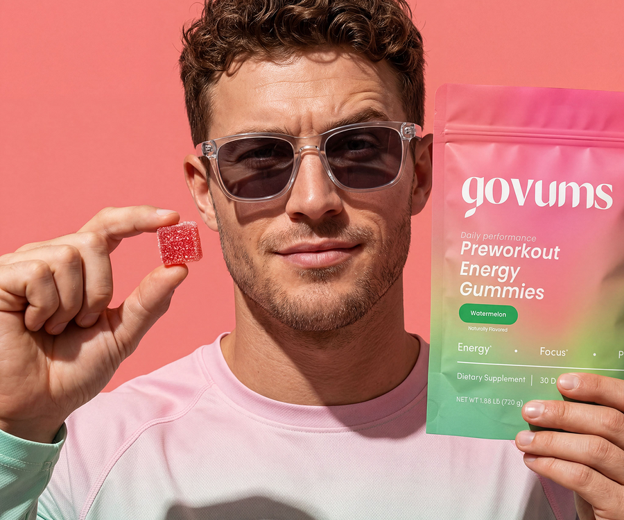 Man holding a gummy supplement and its packaging with a pink background